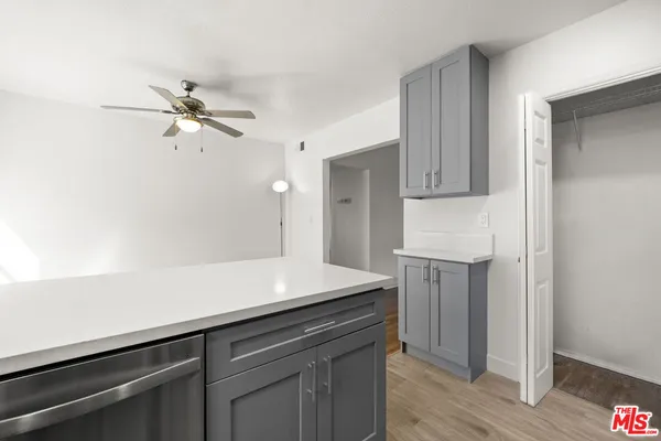 a kitchen with a sink dishwasher and a refrigerator with wooden floor