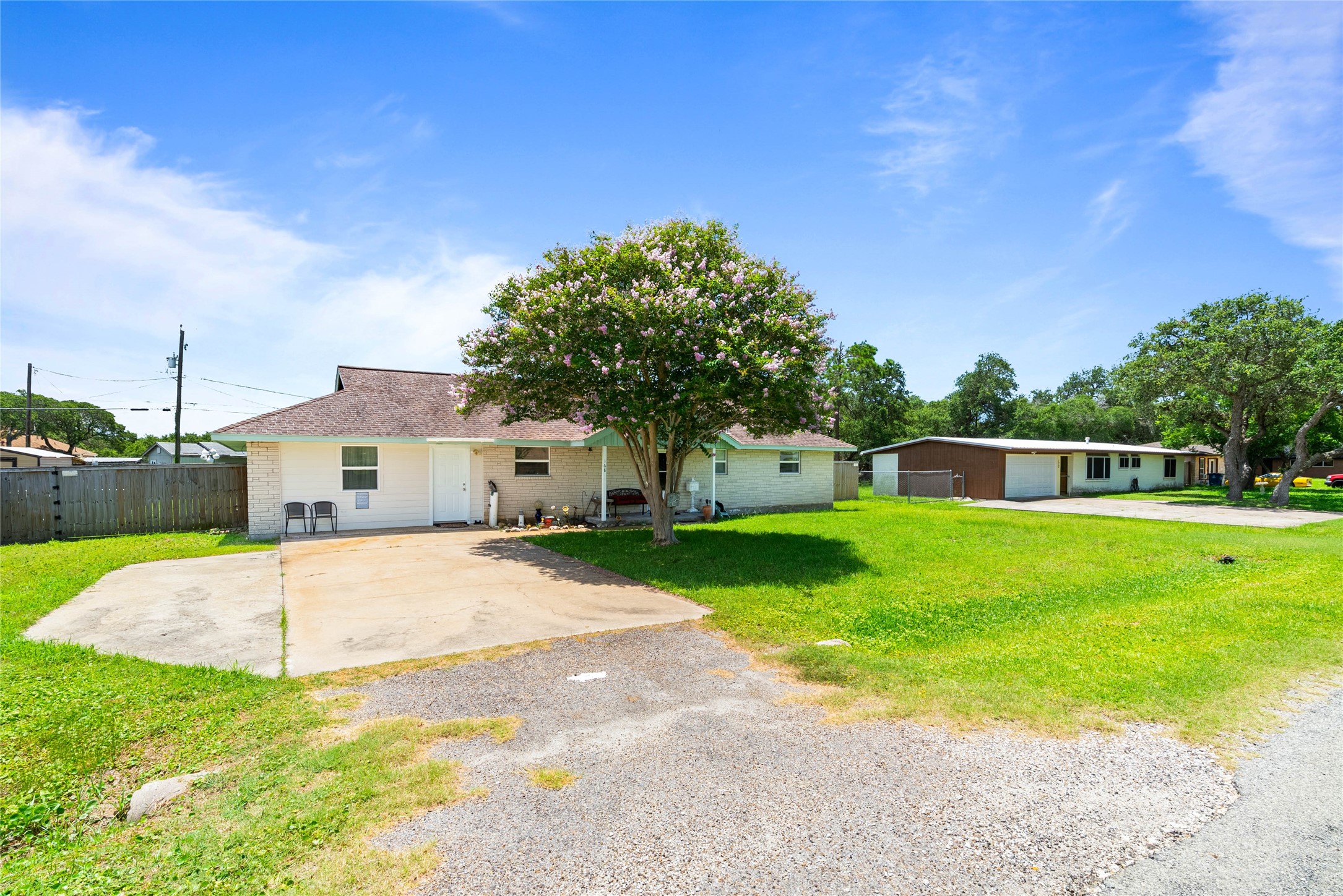 168 Sunset Ingleside, TX 78362 - Photo 2 of 26 Side exterior view highlighting the expansive driveway, garage access, and wide lot layout.