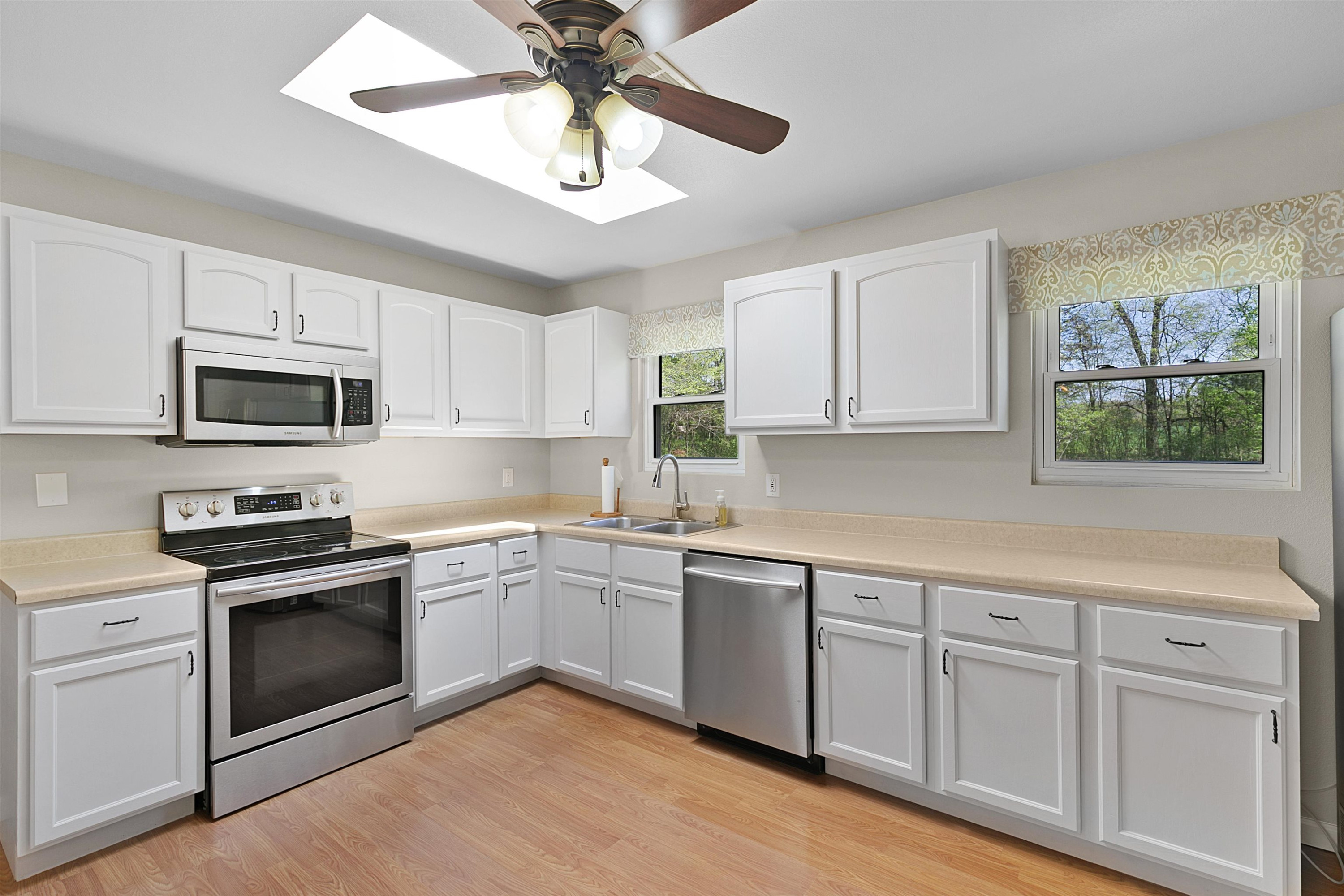 816 Bascom Road Jackson, TN 38305 - Photo 5 of 20 a kitchen with white cabinets stainless steel appliances and a window