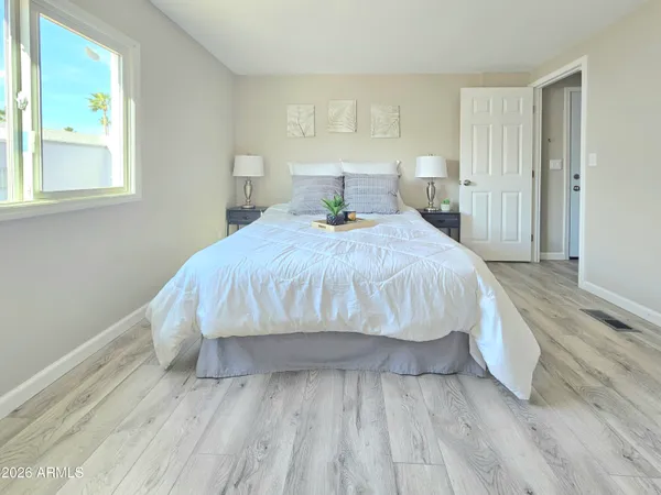 a bedroom with a bed and wooden floor