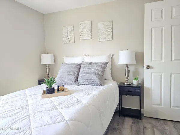a bedroom with a bed and painting on the wall