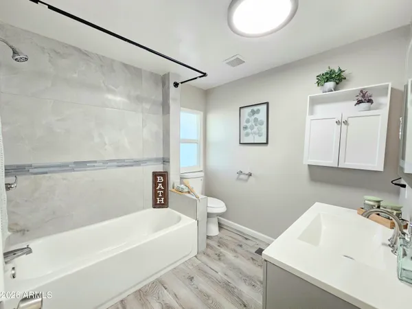 a bathroom with a tub a sink and a large mirror