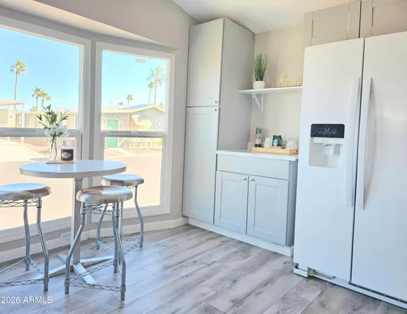 a kitchen with a refrigerator a table and chairs in it