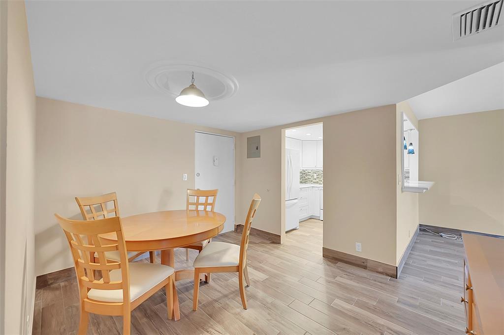 3002 Northeast 5th Terrace, Unit 102B Wilton Manors, FL 33334 - Photo 15 of 44 a view of a dining room with furniture and wooden floor