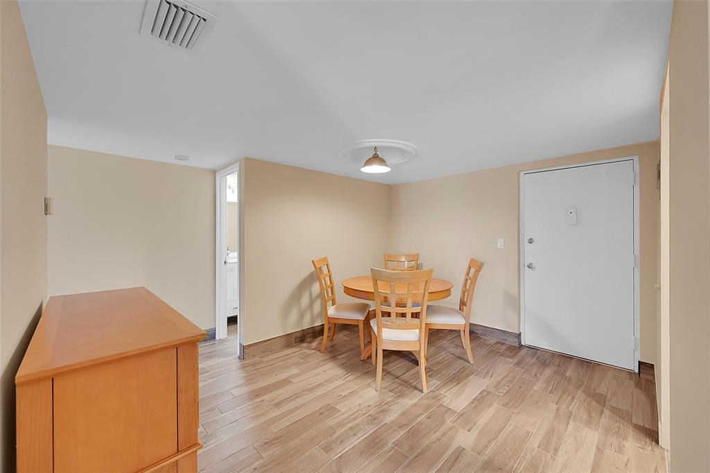 3002 Northeast 5th Terrace, Unit 102B Wilton Manors, FL 33334 - Photo 16 of 44 a dining room with furniture and wooden floor