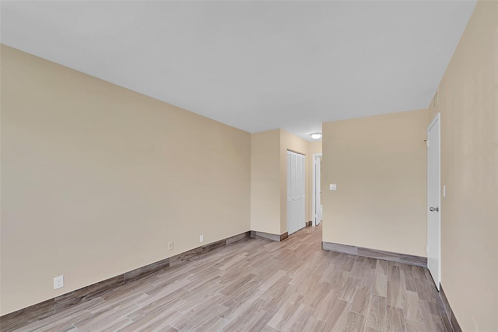 3002 Northeast 5th Terrace, Unit 102B Wilton Manors, FL 33334 - Photo 18 of 44 a view of an empty room and wooden floor
