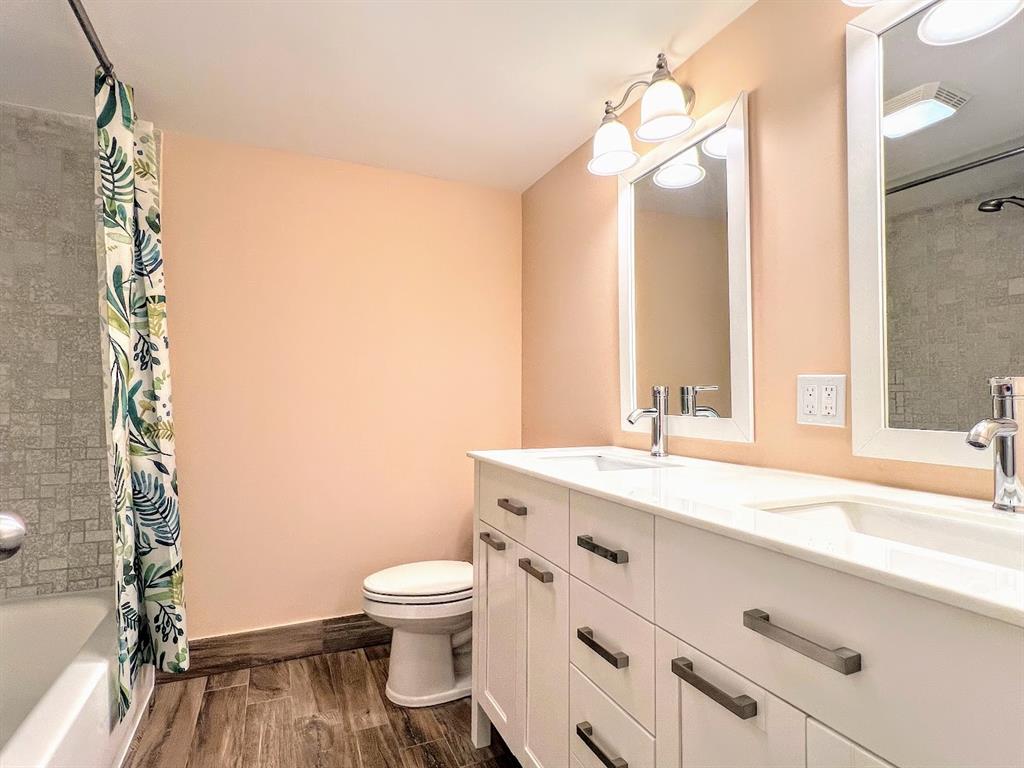 3002 Northeast 5th Terrace, Unit 102B Wilton Manors, FL 33334 - Photo 22 of 44 a bathroom with a granite countertop sink mirror vanity and toilet