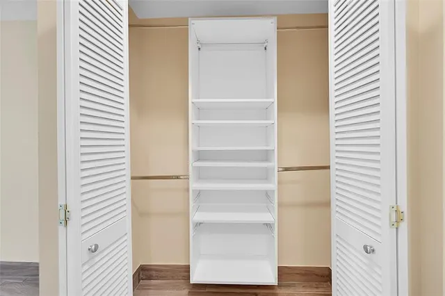a view of walk in closet with empty racks