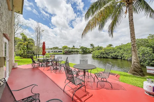 a view of a lake with a table and chairs in patio