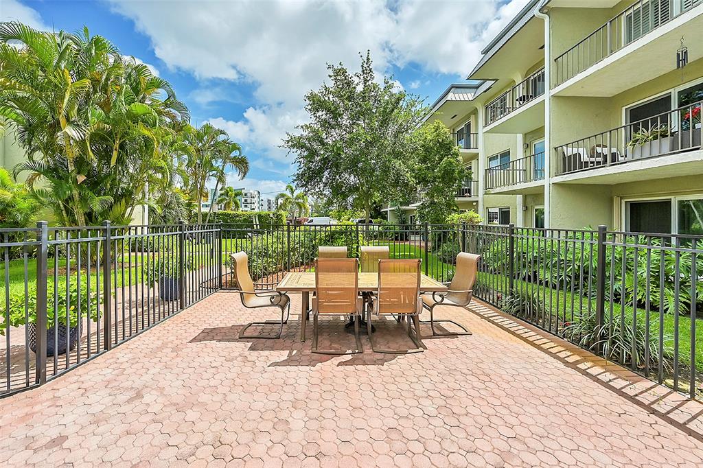 3002 Northeast 5th Terrace, Unit 102B Wilton Manors, FL 33334 - Photo 34 of 44 a view of a building with sitting area and garden