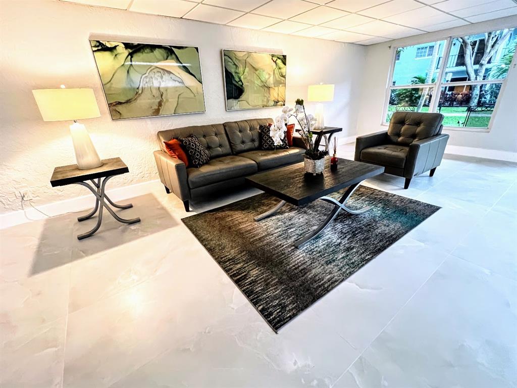 3002 Northeast 5th Terrace, Unit 102B Wilton Manors, FL 33334 - Photo 35 of 44 a living room with furniture and a rug