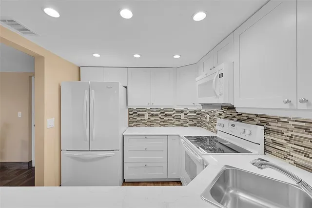 a kitchen with a stove a sink and a refrigerator