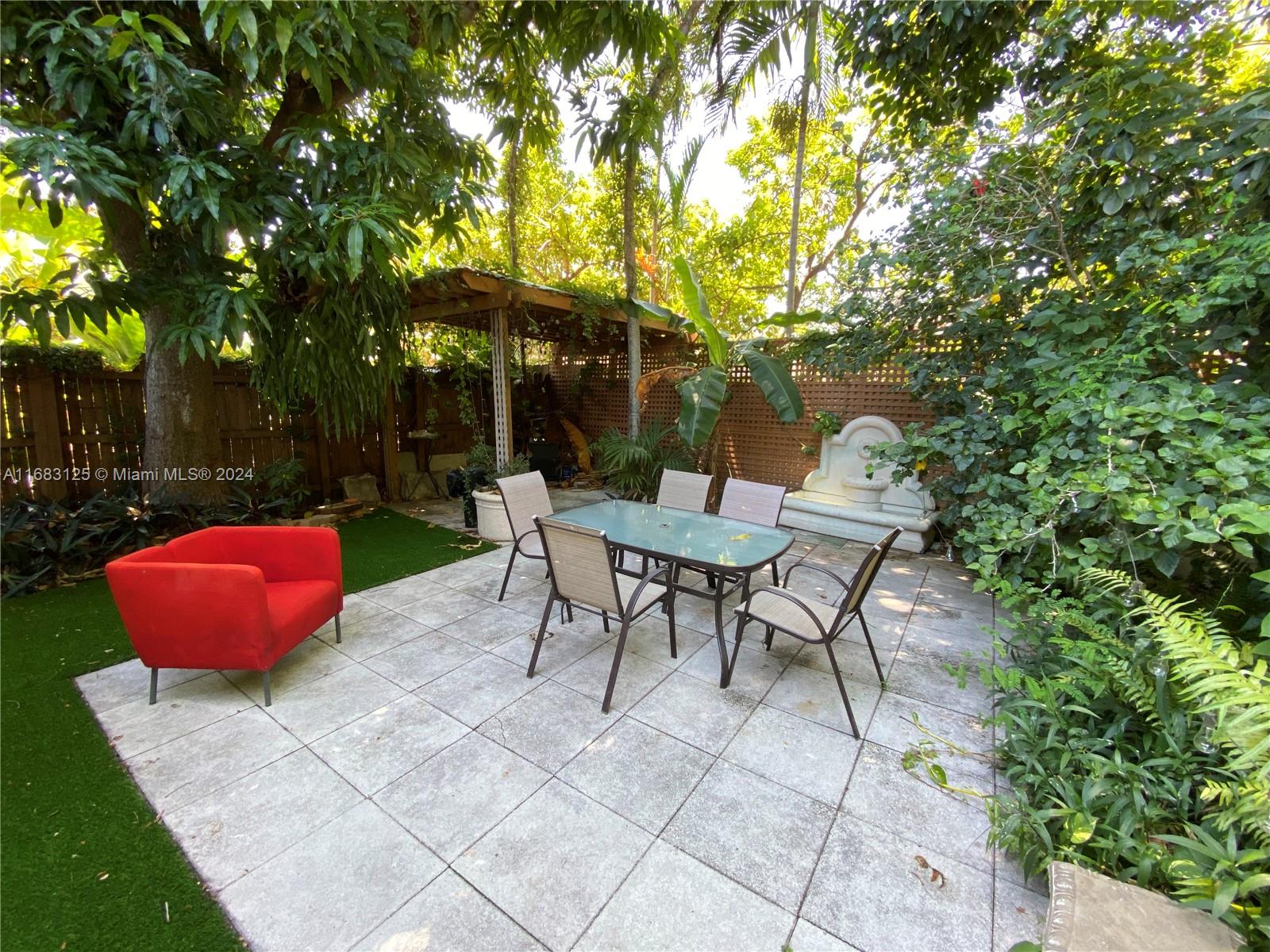541 Northeast 63rd Street, Unit 3 Miami, FL 33138 - Photo 15 of 19 a view of a backyard with table and chairs under an umbrella