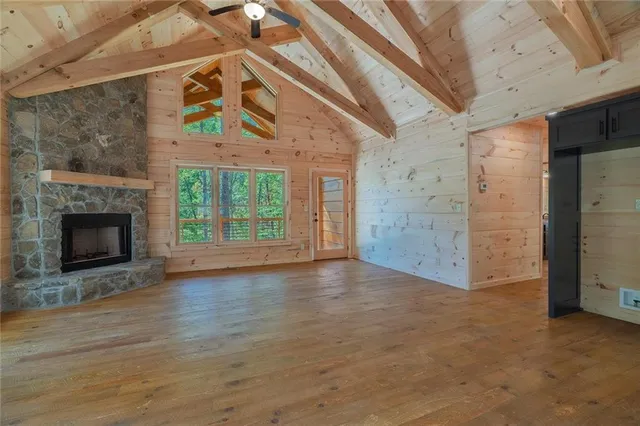 a view of empty room with wooden floor and fireplace