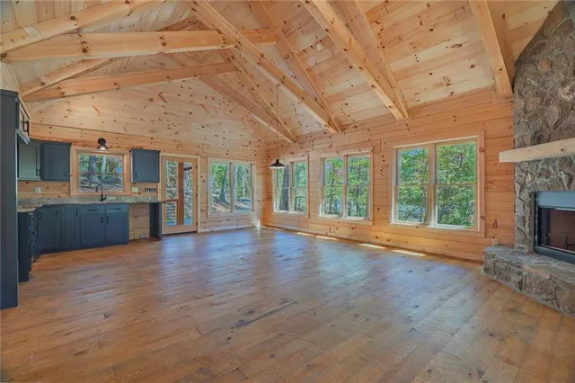a view of a livingroom with wooden floor and a fireplace