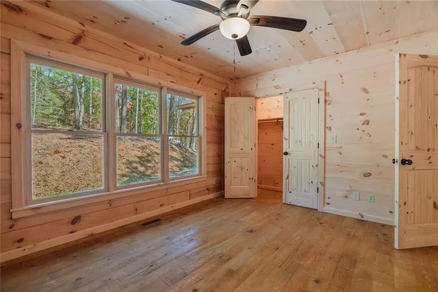 a view of an empty room with a window and a ceiling fan