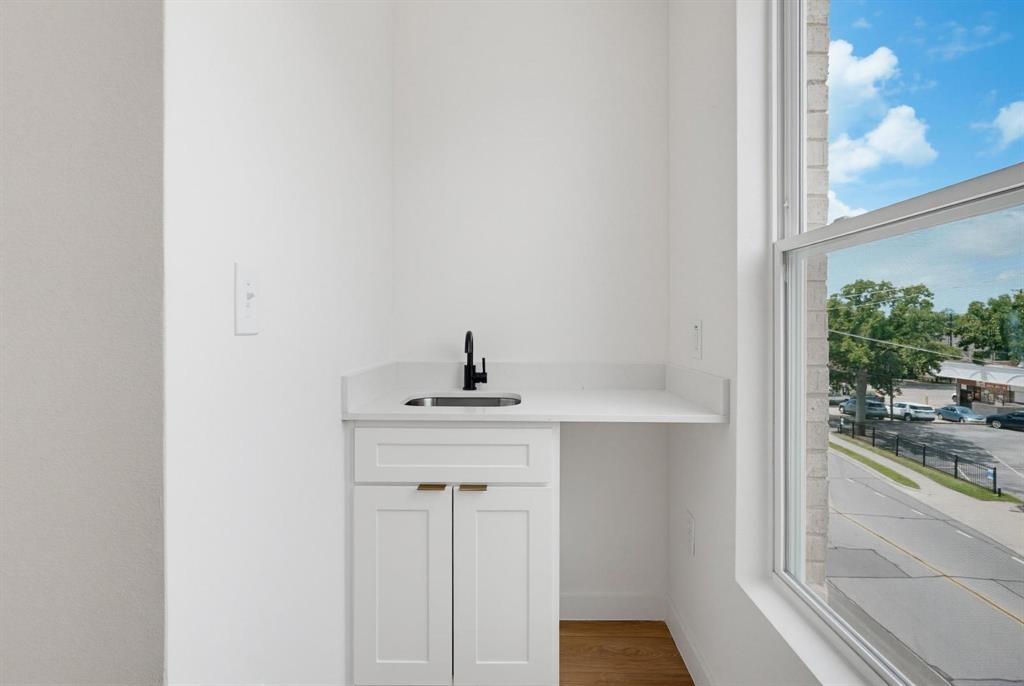 508 South O Connor Road Irving, TX 75060 - Photo 14 of 21 Integrated wet bar featuring a white cabinetry, light-toned countertop, and undermount sink with a matte black faucet