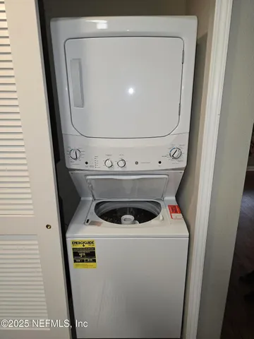 a view of an empty room with a ceiling fan and window