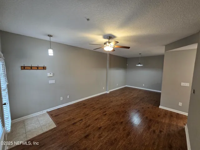 a view of a kitchen with wooden floor and a window