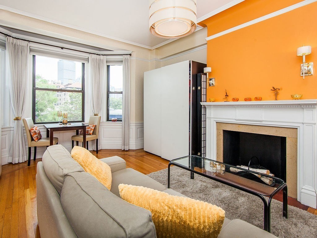 464 Commonwealth Avenue, Unit 36 Boston, MA 02215 - Photo 3 of 18 a living room with furniture a fireplace and a floor to ceiling window