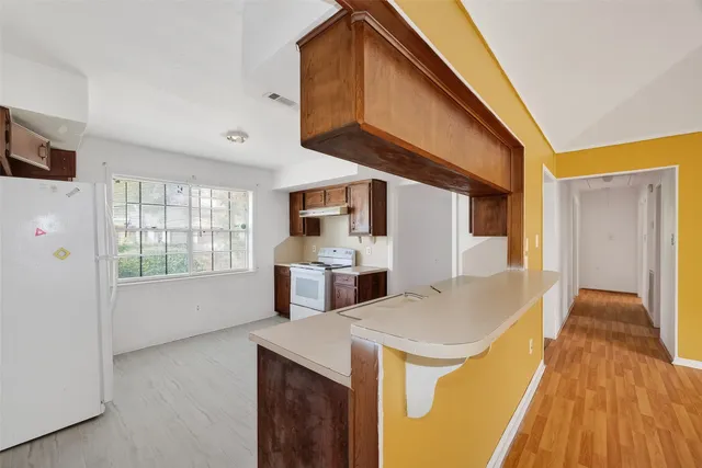 a view of a kitchen with a sink and wooden floor