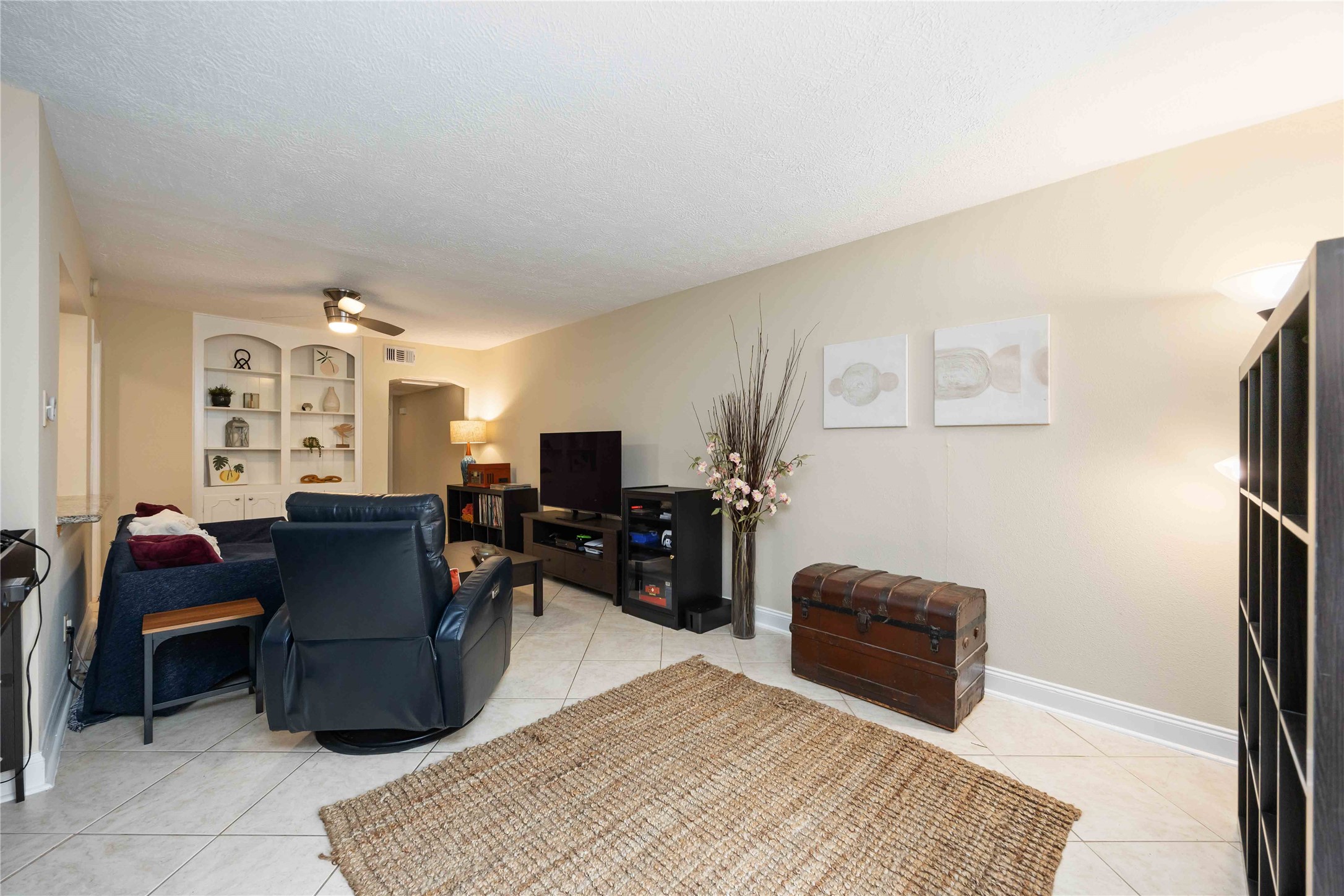 454 North Post Oak Lane Houston, TX 77024 - Photo 7 of 22 a living room with furniture a flat screen tv and a refrigerator