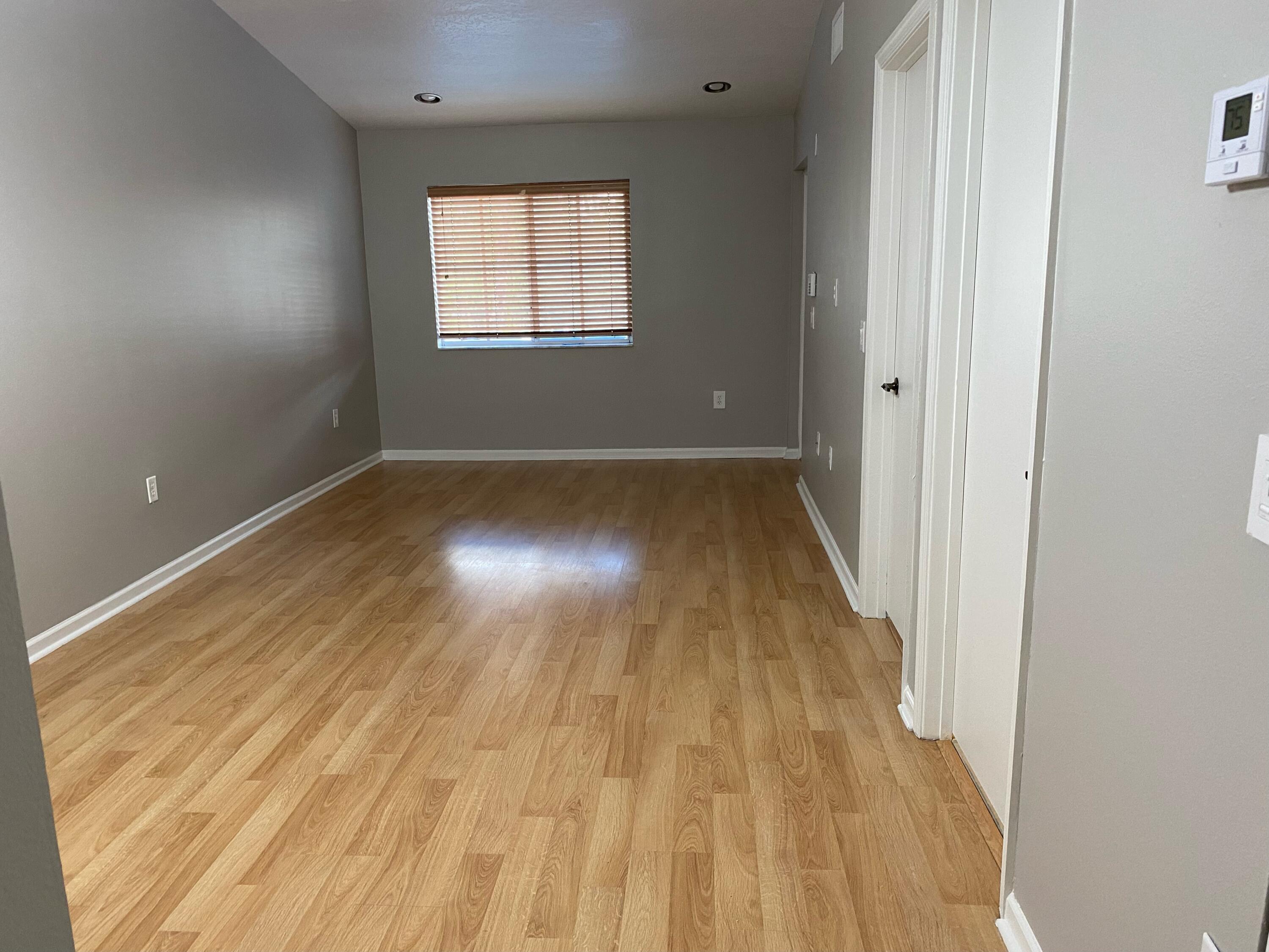 3501 Briar Bay Boulevard, Unit 205 West Palm Beach, FL 33411 - Photo 3 of 8 an empty room with wooden floor and windows