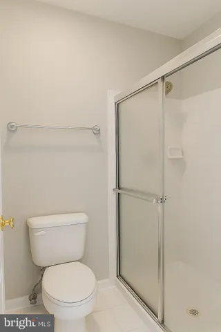 a white toilet sitting next to a shower