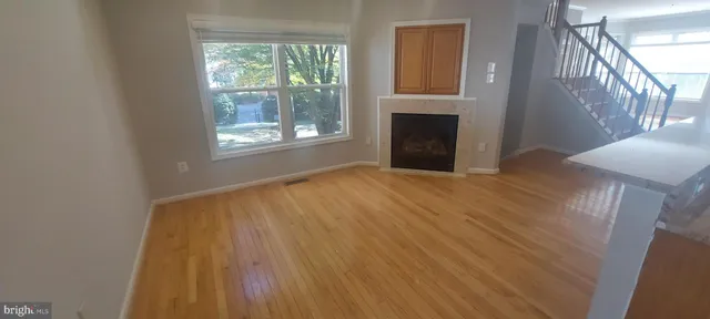 a view of staircase with white walls and wooden floor