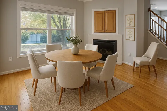 a dining room with furniture a floor to ceiling window and wooden floor