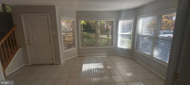 a view of an empty room with windows and a fireplace