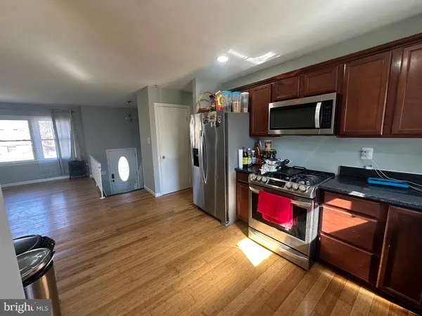 a kitchen with stainless steel appliances granite countertop a refrigerator stove top oven and sink