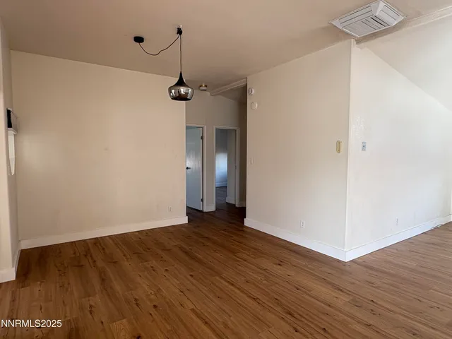 a view of a room with wooden floor and white walls