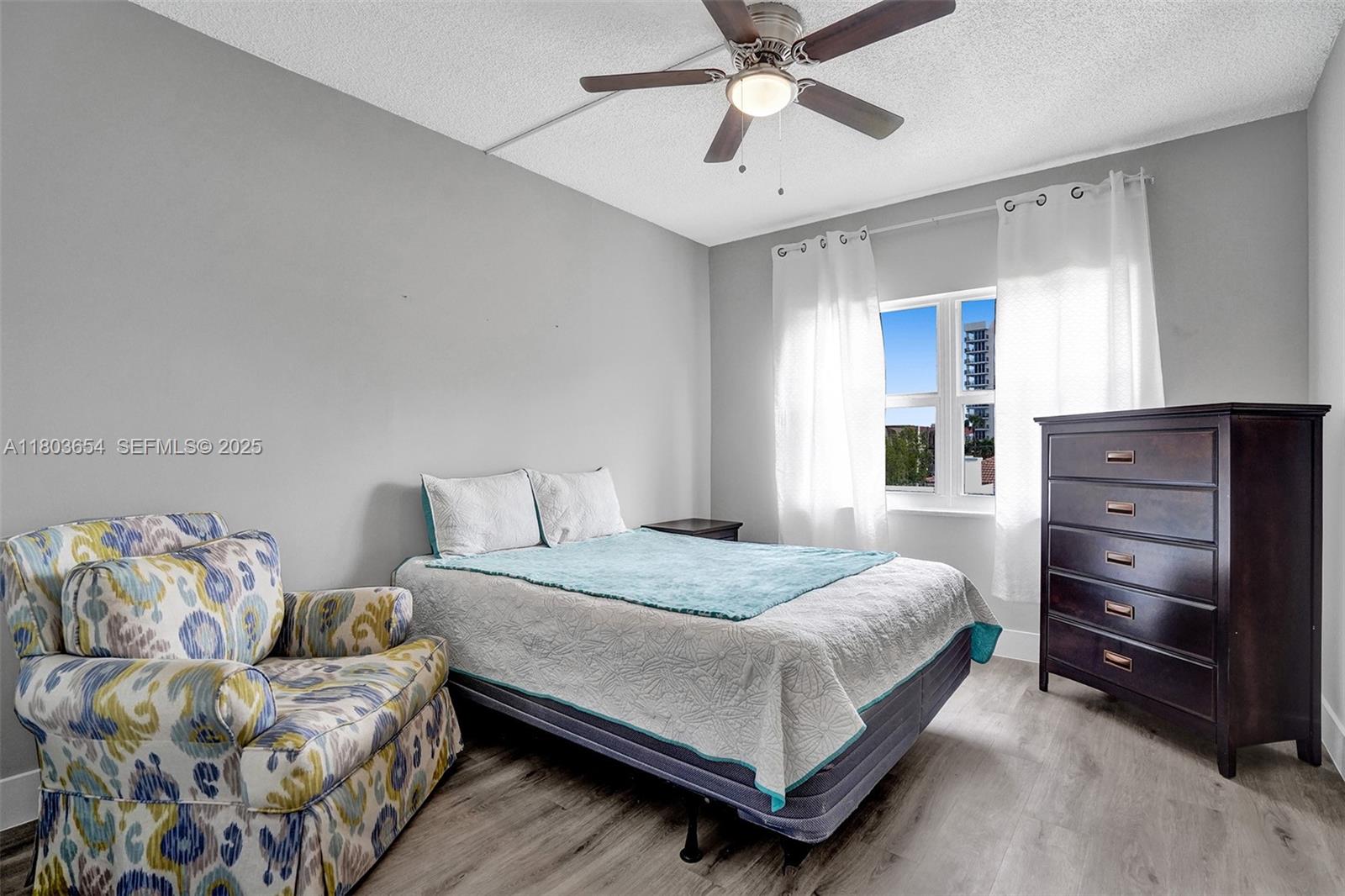 400 North Riverside Drive, Unit 214 Pompano Beach, FL 33062 - Photo 28 of 72 a bedroom with a bed and a chandelier