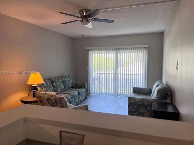 a living room with furniture and a ceiling fan