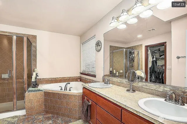 a bathroom with a granite countertop sink a large mirror and a bathtub