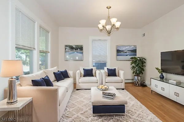 a living room with furniture a flat screen tv and a large window
