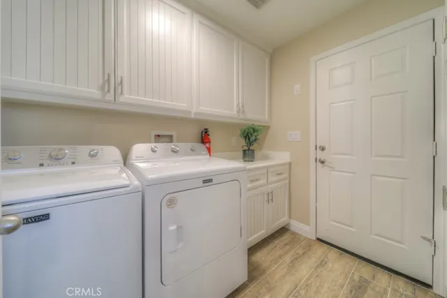 a kitchen with stainless steel appliances granite countertop a refrigerator a sink dishwasher a stove and white countertops with wooden floor