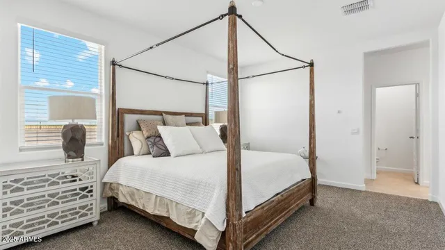 a bedroom with a bed and two windows