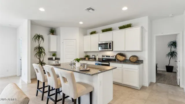 a kitchen with white cabinets and appliances