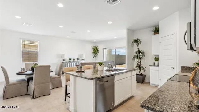 a kitchen with stainless steel appliances granite countertop a sink and a refrigerator
