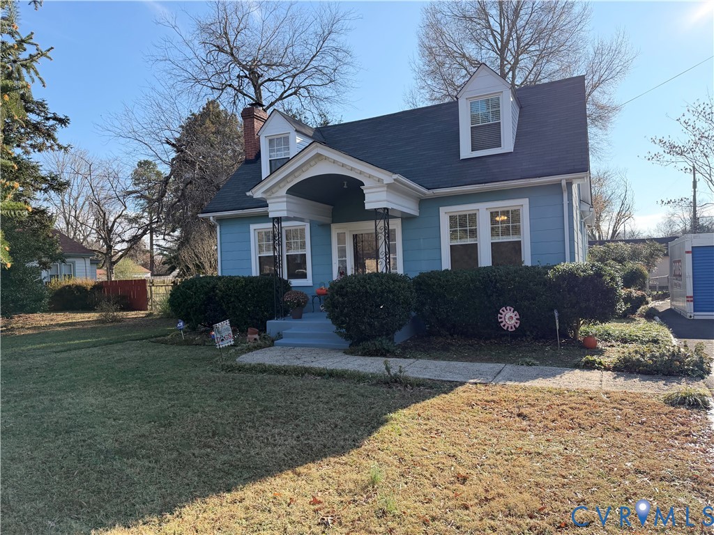 a front view of a house with a yard covered with trees
