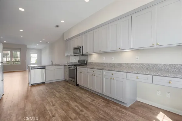 a kitchen with granite countertop white cabinets and white appliances