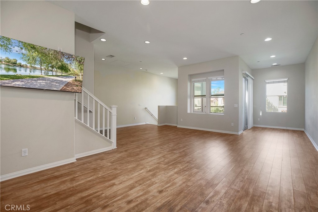 116 Neptune Irvine, CA 92618 - Photo 4 of 25 an empty room with wooden floor and windows