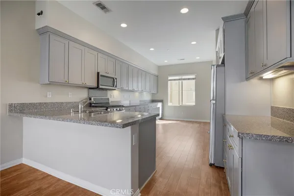 a kitchen with stainless steel appliances granite countertop a sink stove and cabinets