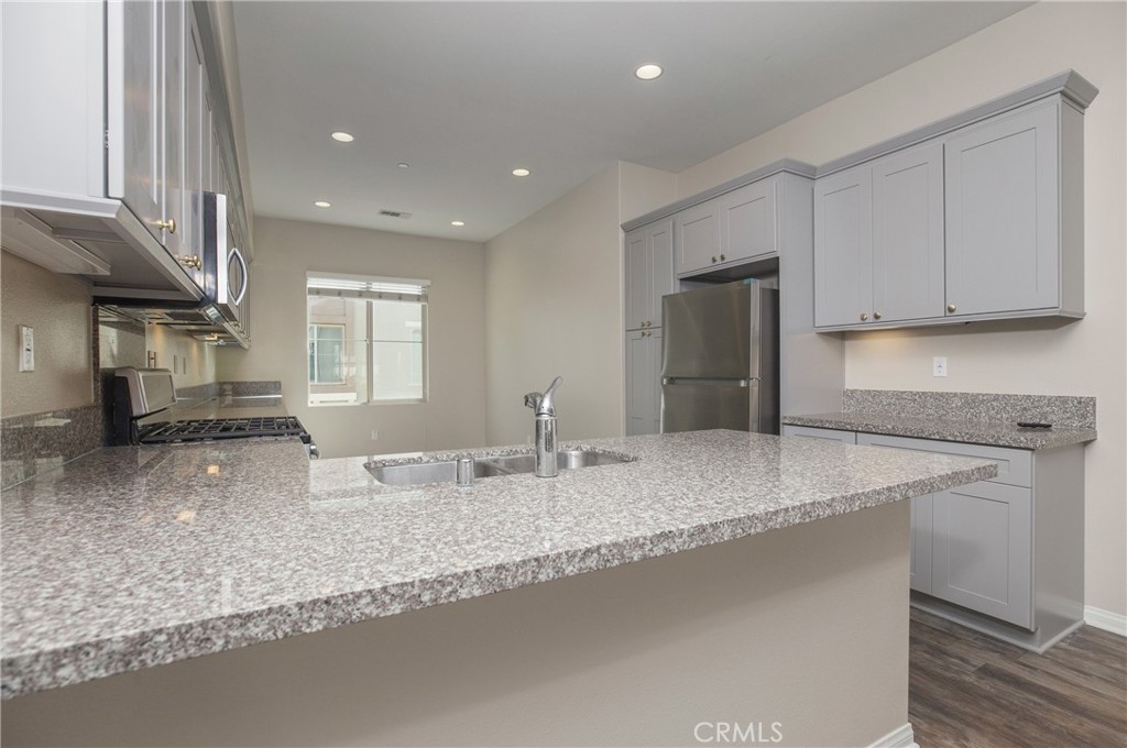116 Neptune Irvine, CA 92618 - Photo 10 of 25 a kitchen with stainless steel appliances granite countertop a sink a stove and a refrigerator