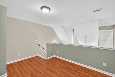 a view of a room with wooden floor and fan