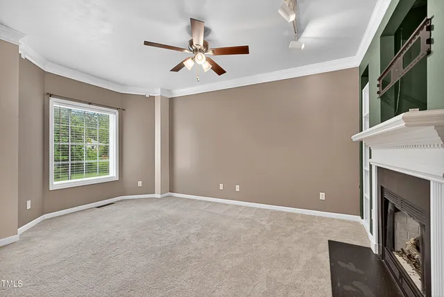a view of an empty room with a fireplace and a window