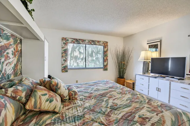 a bedroom with a bed and a flat screen tv
