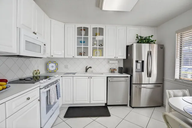 a kitchen with stainless steel appliances granite countertop a refrigerator sink and cabinets
